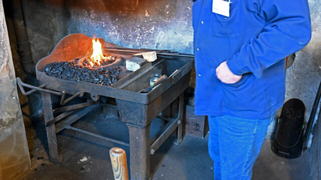 In the forge, a steel bar is heated to incandescence