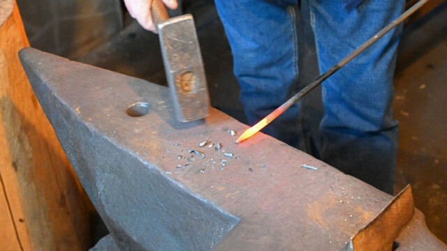 The glowing iron rod is struck into shape