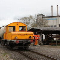 © Peter Hürzeler
Vor den Gebäudlichkeiten der Papierfabrik Cham präsentiert sich die Akku-Lok von 1919 mit ihrem Rangierpersonal. Akku-Lok von 1919