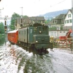 Die Rorschach Heiden Bahn RHB traut sich nicht mehr, ihre Triebwagen ABDeh 2/4 mit ihren tief im Drehgestell sitzenden Motoren ins Wasser zu schicken. Die Ae 3/6I 10648 mit dem B11 der RHB hat als Ersatz diesbezüglich kein Problem und stampft in Rückwärtsfahrt (Signal offen und Verlauf der Wellen) durchs Wasser. 01.08.1987 Foto: E. Meier