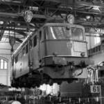 Die Ae 6/6 11437 mit Ihren 120 Tonnen Gewicht hängt wie eine Modelllokomotive an 4 Kranhaken.     27.10.1974 
  Foto: Edi Meier, Bülach